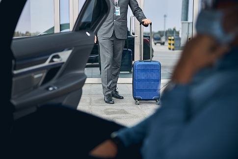 AdobeStock_388783762 1-compressed Homme avec une valise qui approche une voiture
