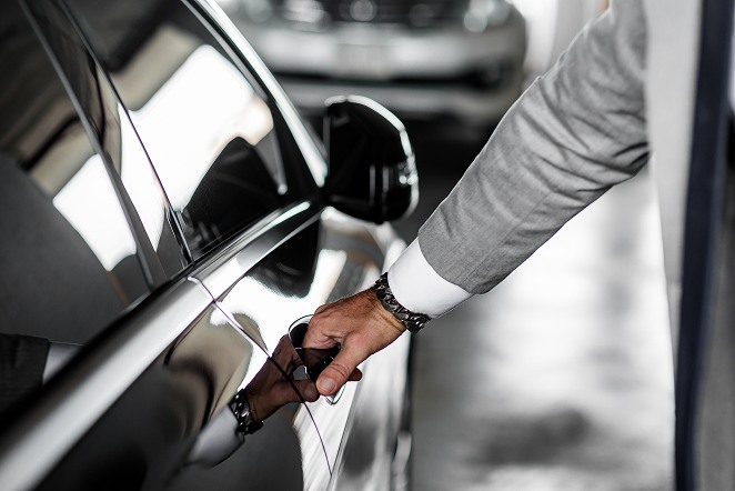 Homme sur le point d’ouvrir la portière d’une voiture Homme sur le point d’ouvrir la portière d’une voiture